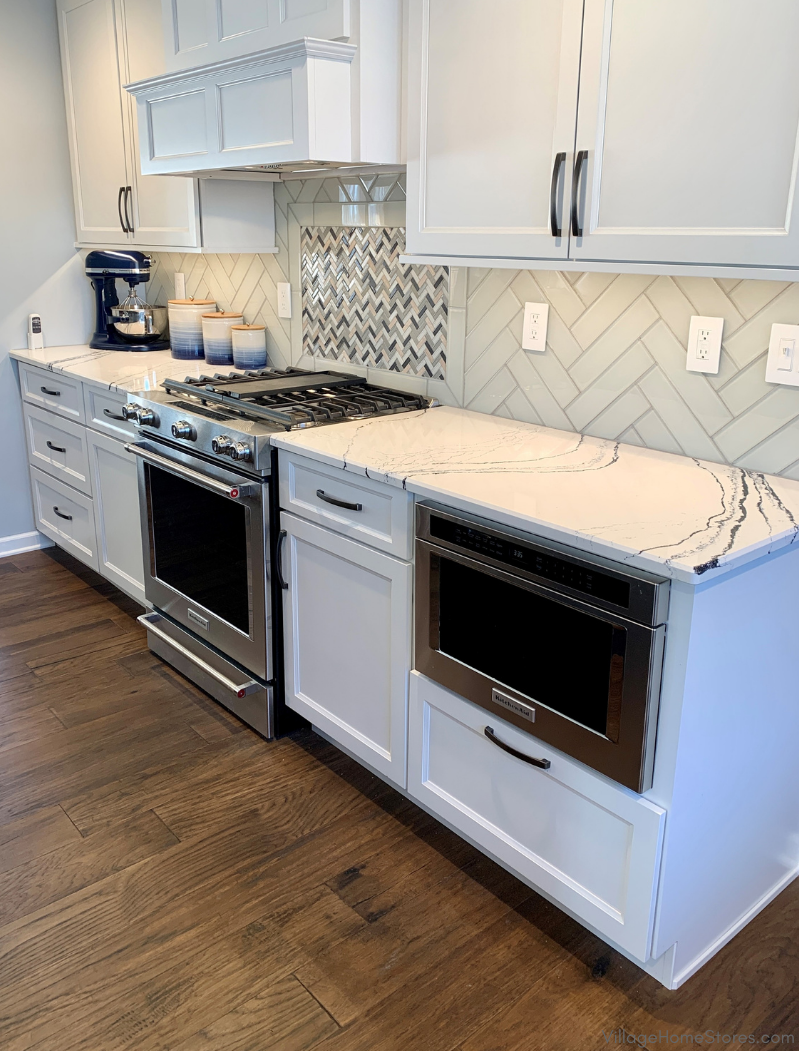 Kitchen with white cabinets and stainless steel gas range and microwave drawer