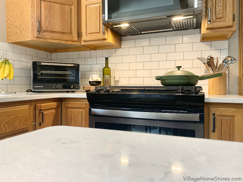 Kitchen island counter in Cambria Swanbridge with gas cooktop and green always pan in background