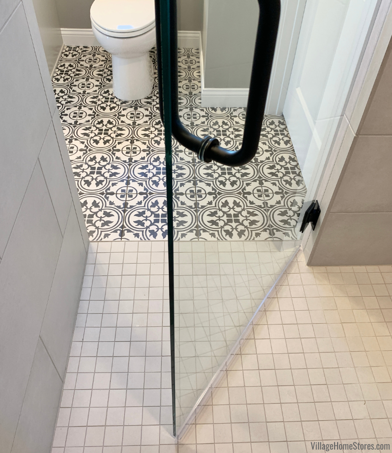 Image showing black and white bathroom floor tile in main area and custom tiled shower.