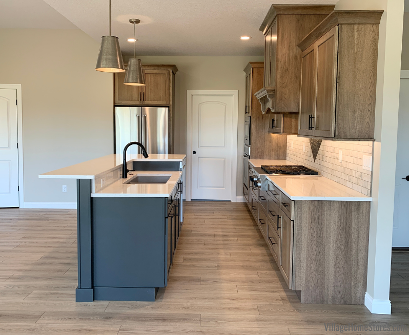 Hickory kitchen with two level island. Dura Supreme cabinets, Cambria quartz and COREtec vinyl plank flooring featured. 