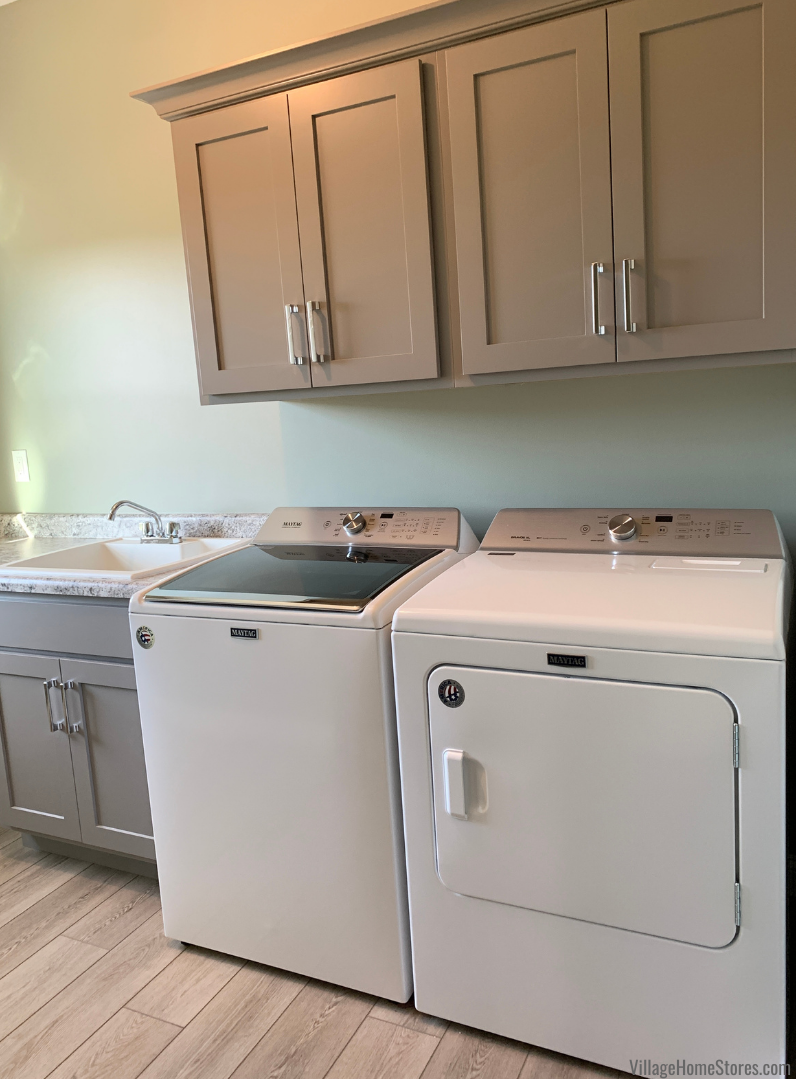 Laundry room with white laundry pair and gray painted cabinetry.