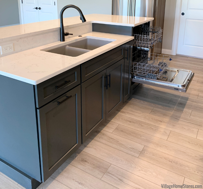 Kitchen island in dark painted Graphite finish. Raised dishwasher design with door shown open. Kitchen design and appliances from Village Home Stores. 