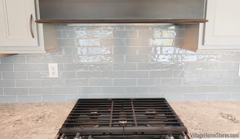 Blue elongated subway tile on wall of kitchen with tile endcap Schluter strip and Cambria Summerhill quartz counters