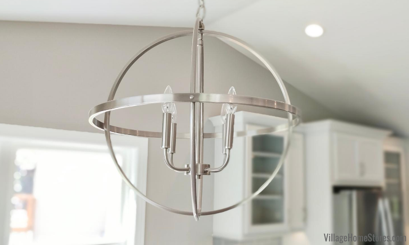 Nickel finish sphere foyer light hanging in dining area of open concept kitchen. Capital HomePlace lighting from Village Home Stores for Hazelwood Homes of the Quad Cities
