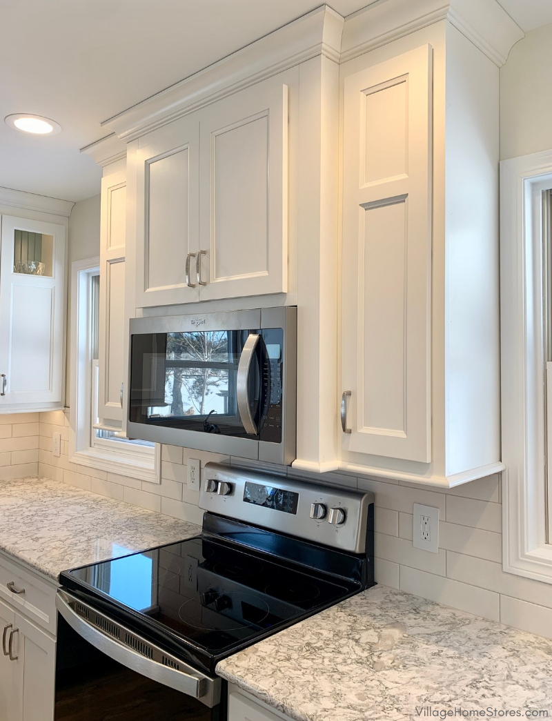 microwave hood with cabinets surrounding it staggered in depth with crown molding to ceiling