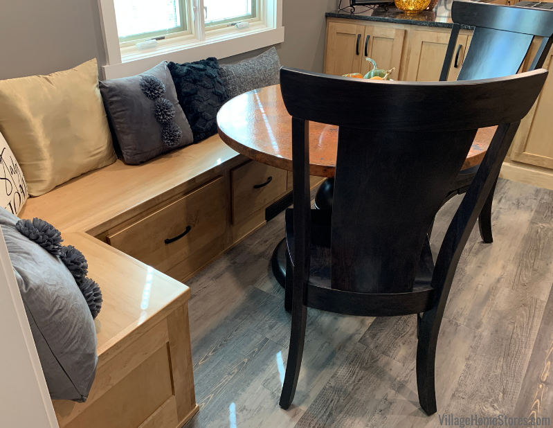 Image of bench seat with round dining table and black chairs