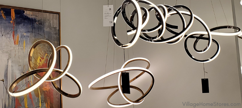 curved and tangled LED contemporary artistic light fixtures hanging in a lighting showroom 