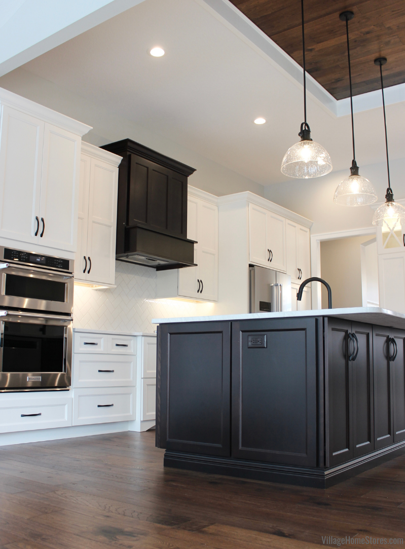 Great room kitchen with Ivory and Java cabinets and seeded glass matte black pendants above kitchen island.