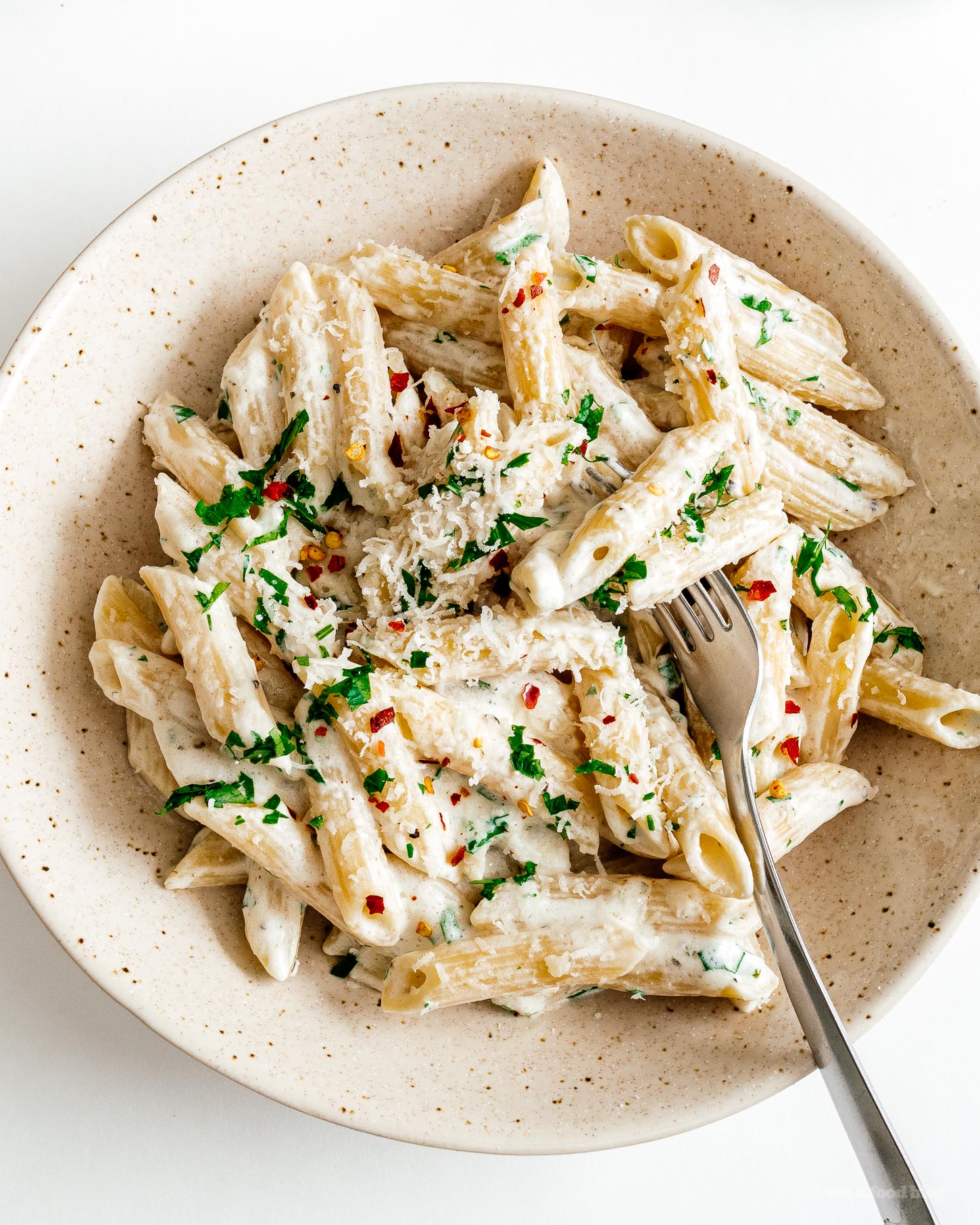 Overhead shot of creamy Boursin pasta in a speckled bowl