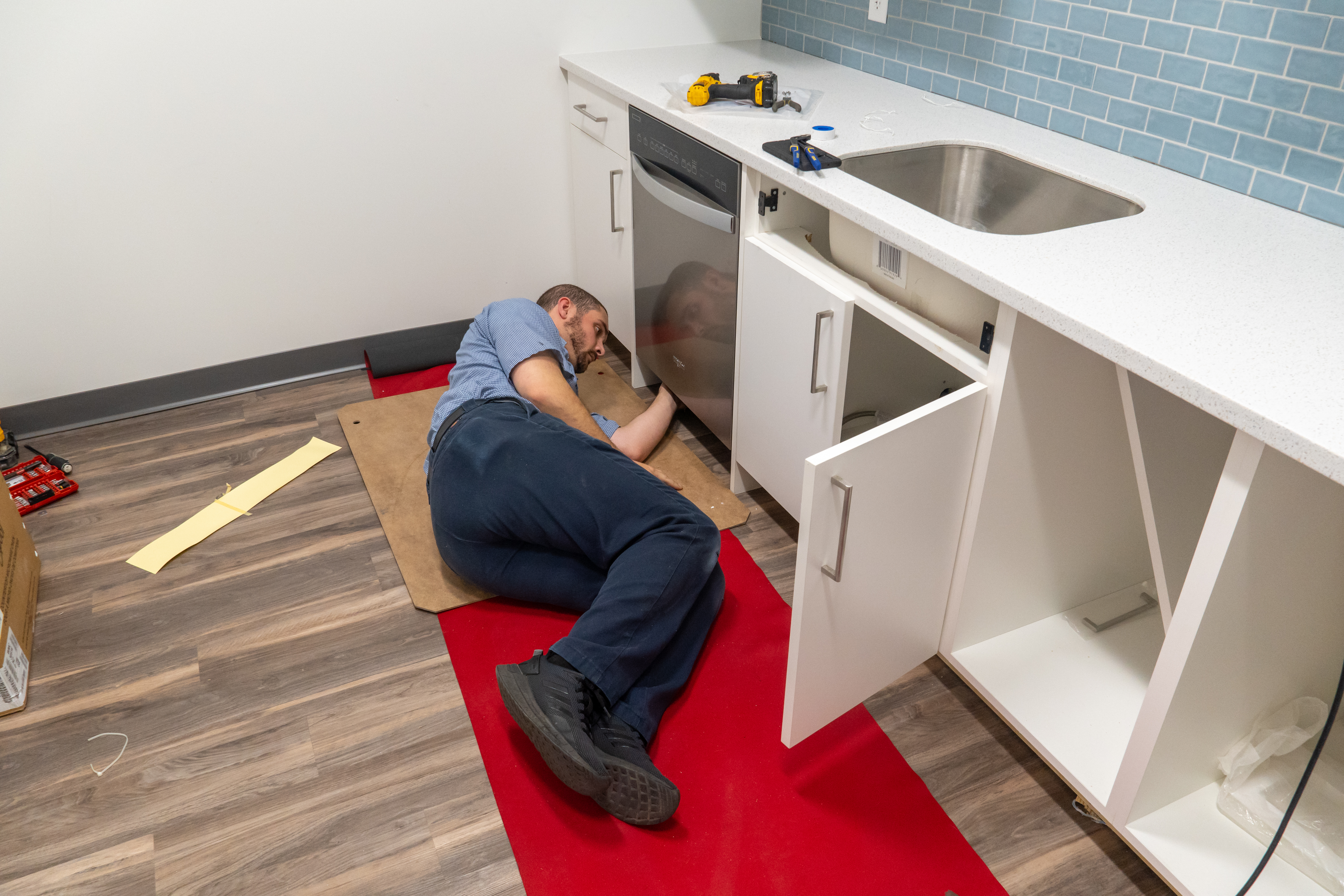 Professional installer putting in a dishwasher at Community Action House