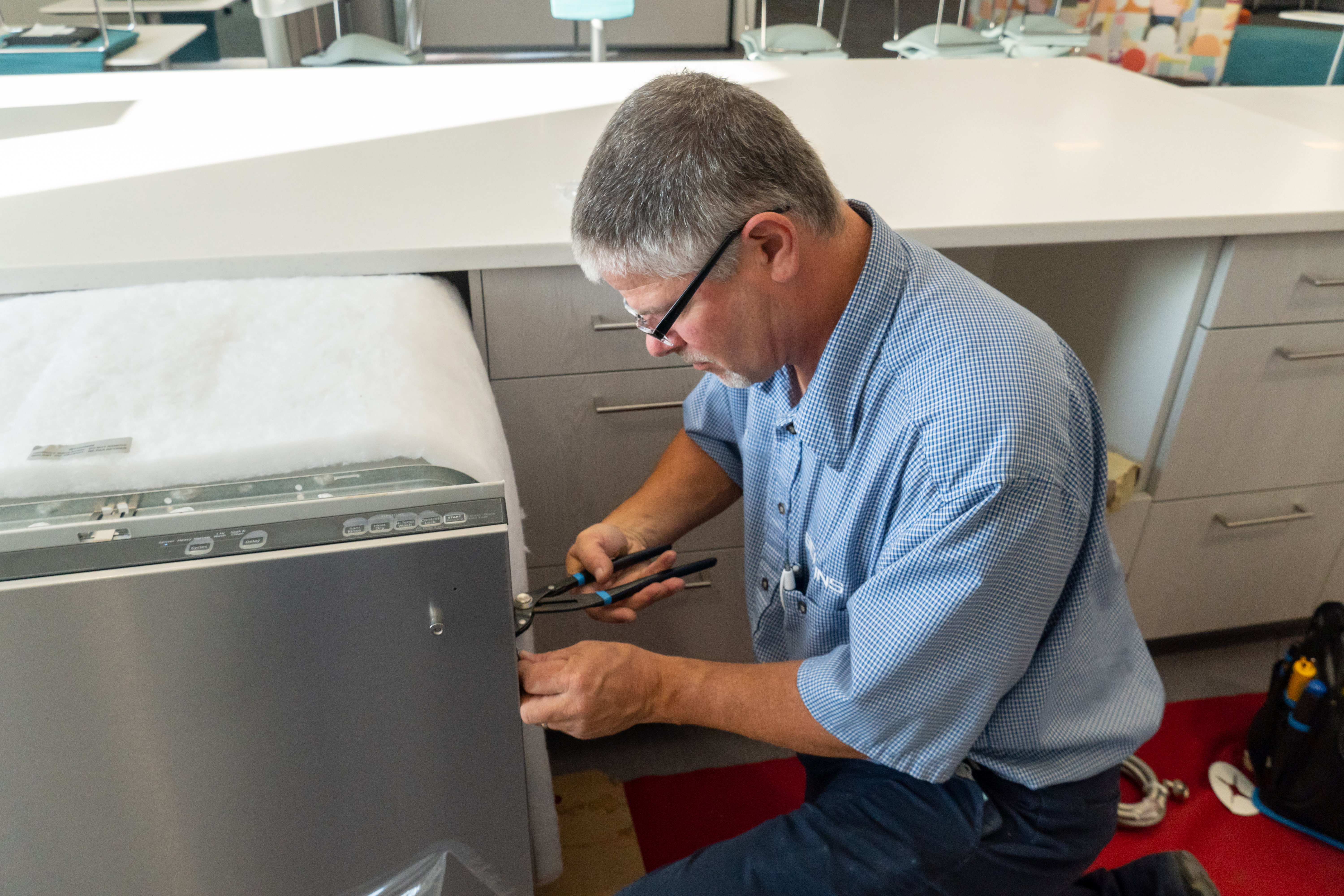 Bekins professional installer putting in an appliance in Community Action House kitchen