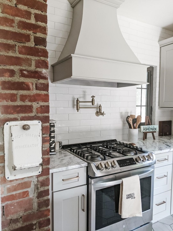 Modern style kitchen appliances next to a vintage brick wall.
