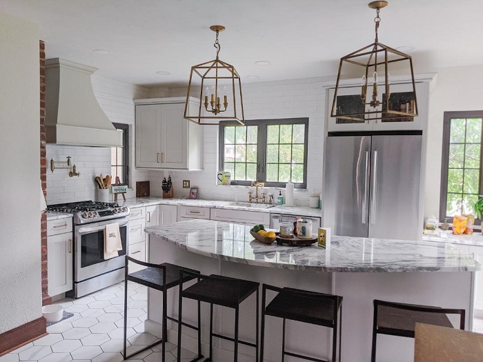 Well lit modern kitchen with marble countertops.
