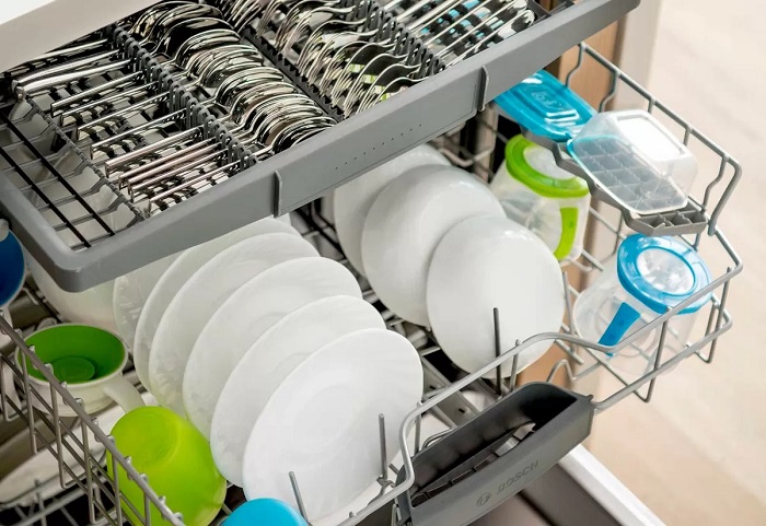 Open dishwasher filled with clean dishes and silverware.