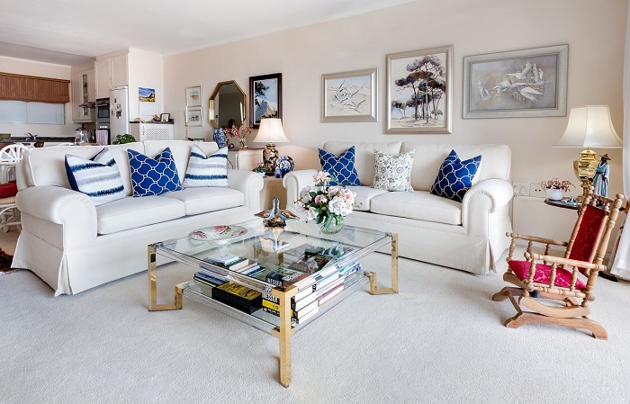 Modern living room with two sofas and assorted artwork in the background. 