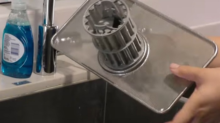 A filter being washed in the sink.