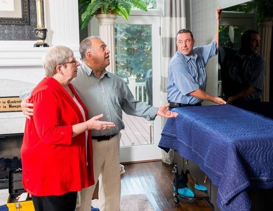 Elderly couple getting a TV installed in their living room.