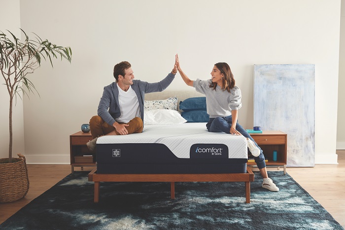 A couple high fives on a new mattress.