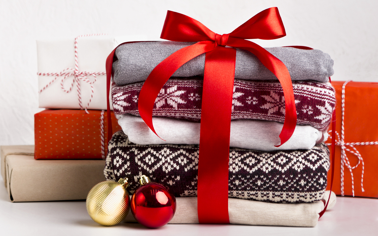 stack of Christmas sweaters tied in gift wrap