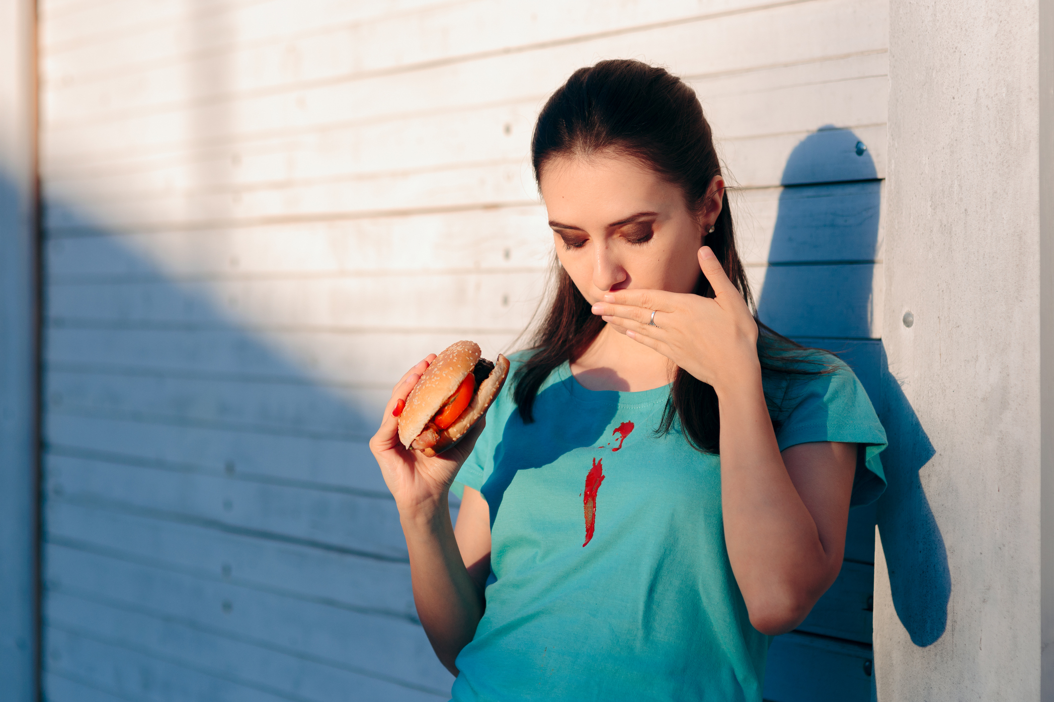 woman spilling ketchup on her shirt
