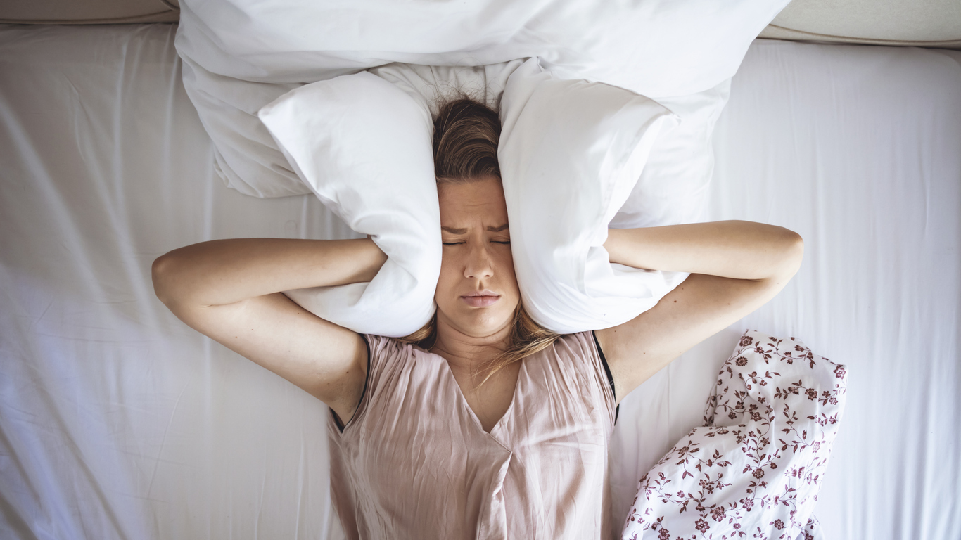 Woman with head between pillows. 