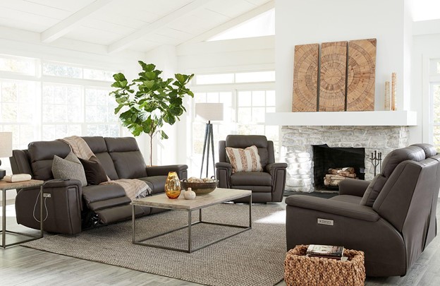 Modern living room with fireplace and three pieces of brown leather furniture.