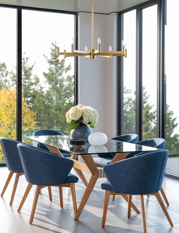 Coastal style dining room with large windows and glass table.