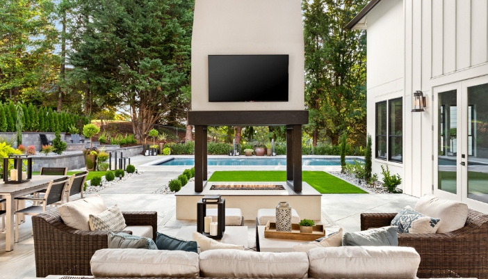 A luxury outdoor lounge with a tv and comfortable seating