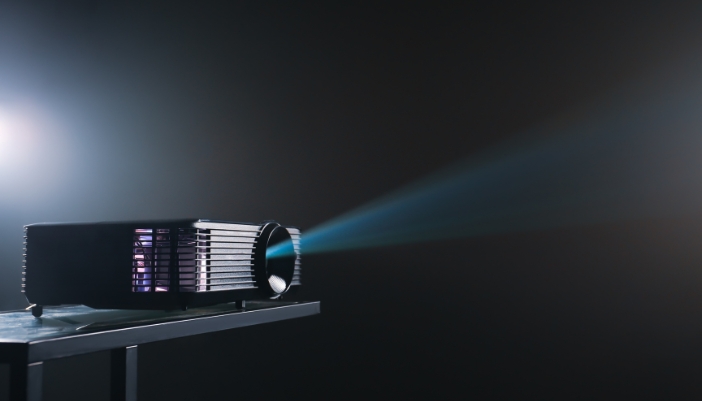 Closeup of a projector emitting light in a dark room