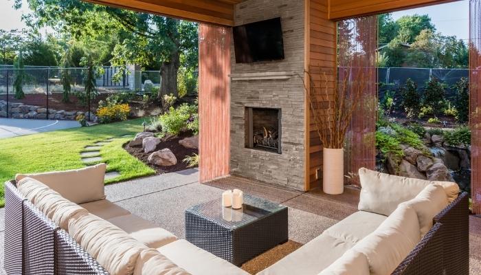 Covered patio with TV, fireplace, and sectional
