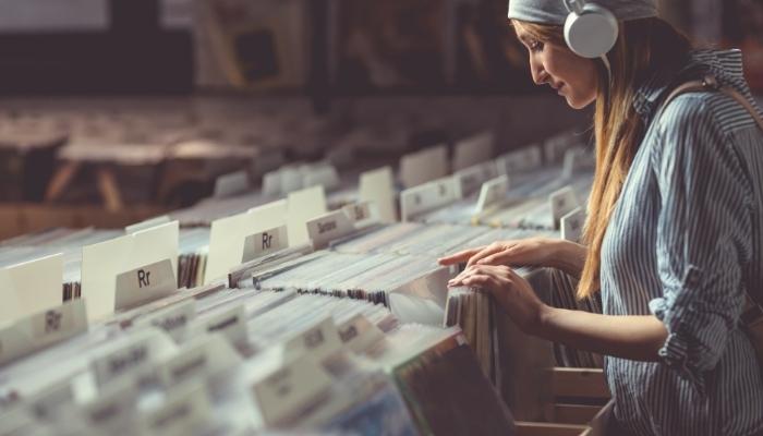 Woman combing through vinyl records in a store