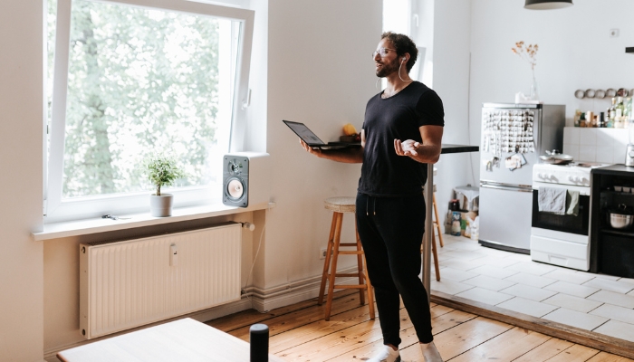 Man working from home with voice-assistant enabled headphones