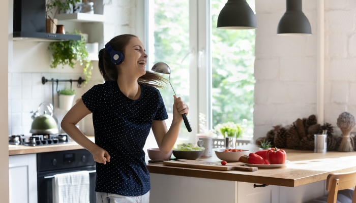 Woman singing along to music through headphones