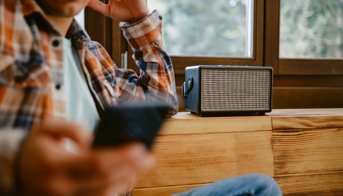 Man streaming music through wireless speaker