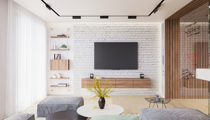 A TV is mounted on a white brick wall with wooden accents throughout the living room.