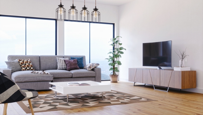 A modern living room with gray furniture and a flat screen TV.