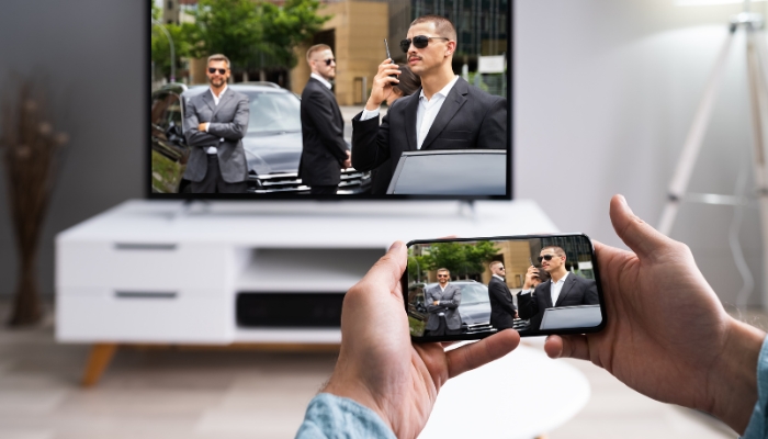 Person casting streaming service from phone to TV