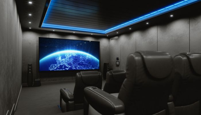 A darkened home theatre with movie theater type seating and a blue planet on the TV screen