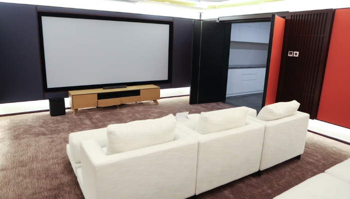 A home theater with a fixed, large projector screen