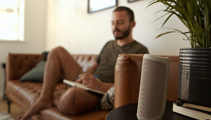 Man listening to music through his Bluetooth speaker while he draws
