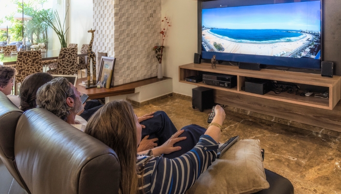 A beautiful home theater set up with a big screen tv and a sound system