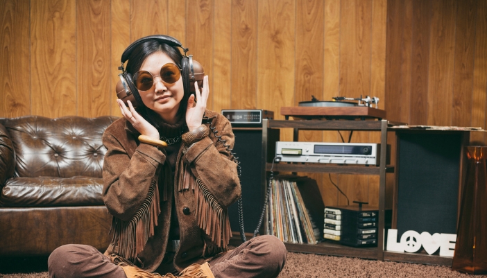A woman listening to music through her retro home stereo system and headphones