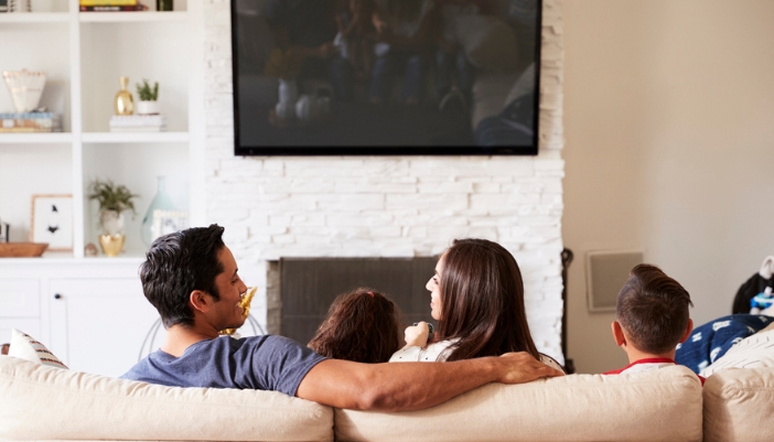 A family relaxes together on a couch at home.