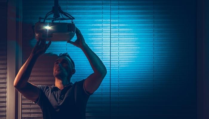 Man adjusting projector for better image