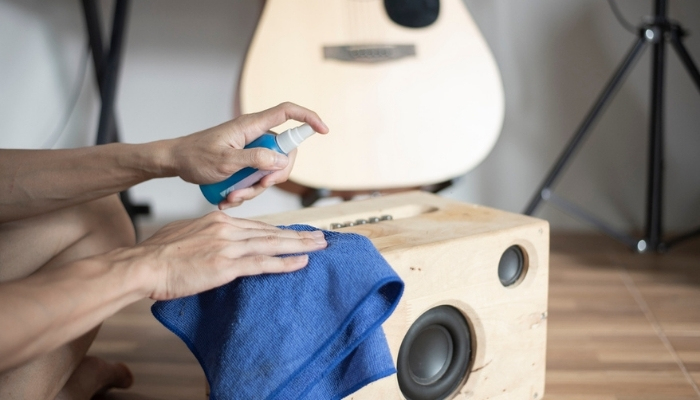 man cleaning speakers