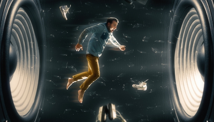 Caricature of a man floating on soundwaves between two speakers and is blown away