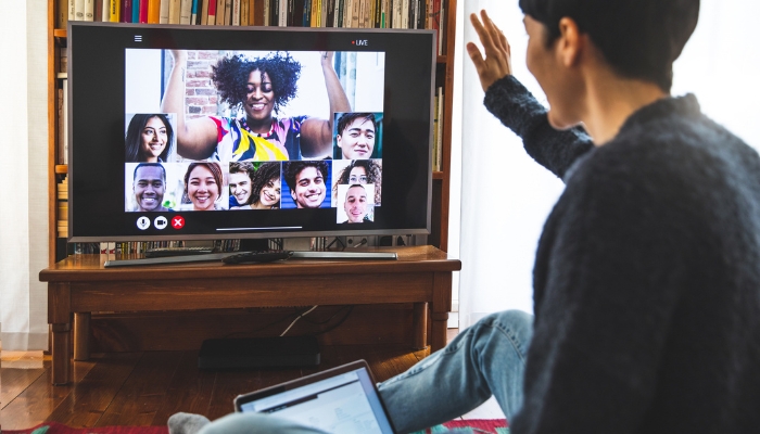 Woman using her TV to video conference while working from home