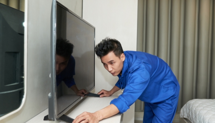 A man adjusting the placement of his TV