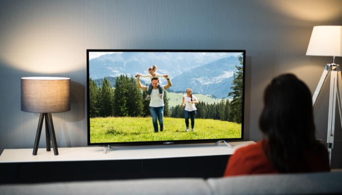 A living room with ambient lighting positioned behind and to the sides of the TV
