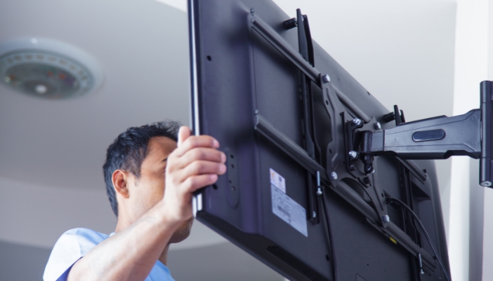 A man extending his TV with a fully articulating wall mount